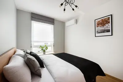 Łóżko lub łóżka w pokoju w obiekcie Wola Skwer Sunny Apartment by BookingHost